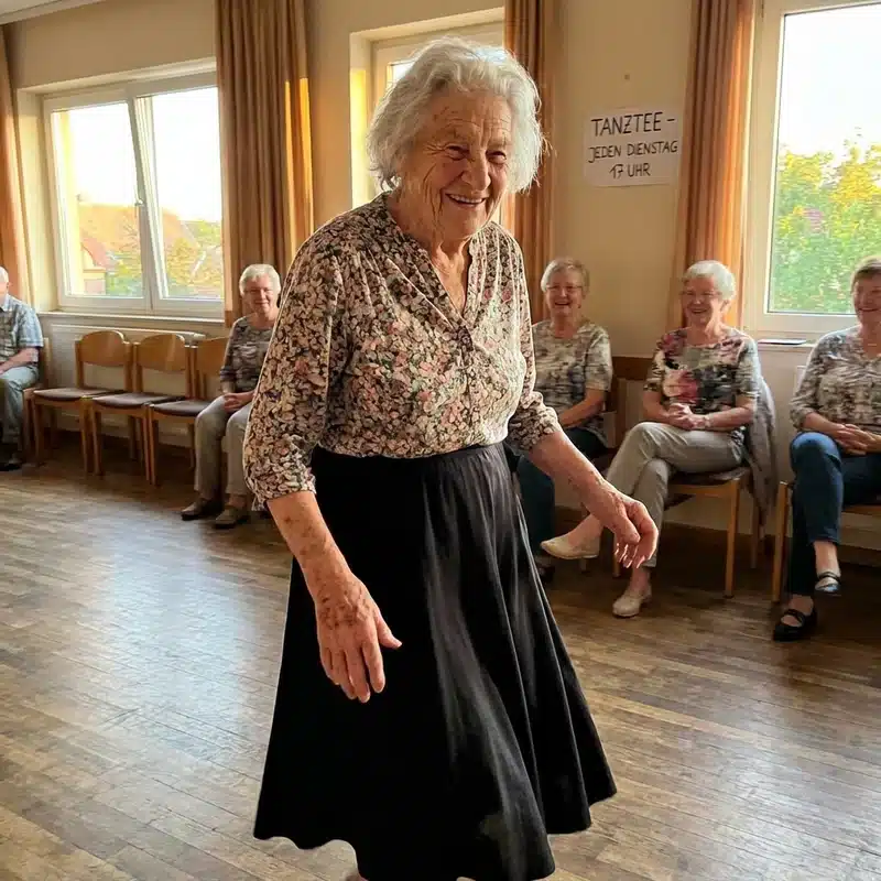 Gerda tanzt in Tanzsaal, Rock schwingt, warmes Abendlicht, andere Senioren schauen zu